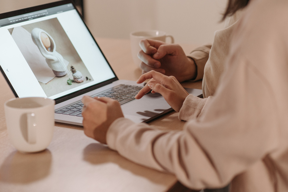 A person editing photos on a laptop in front of a desk.
