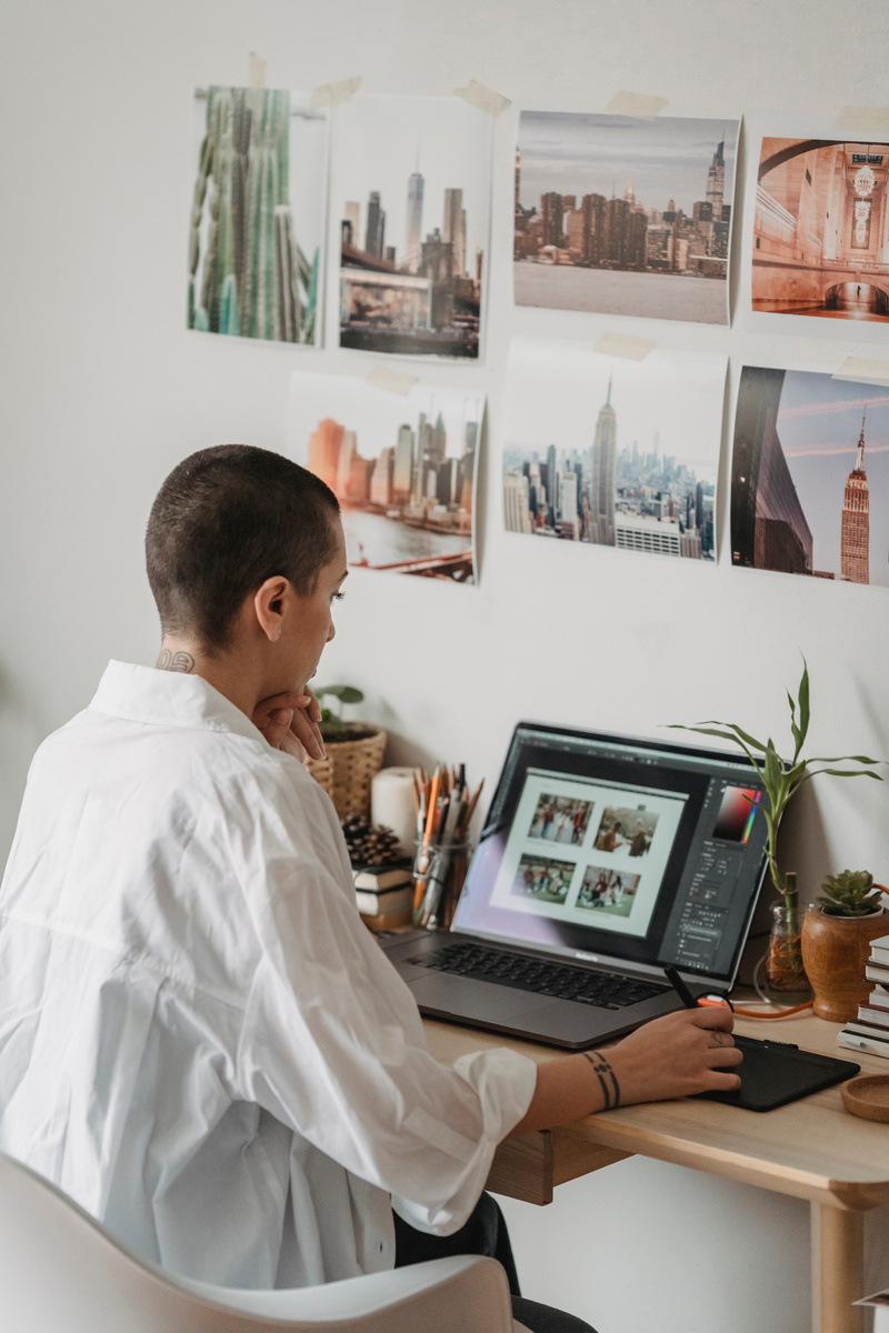 A person editing photos on a laptop in front of a desk.